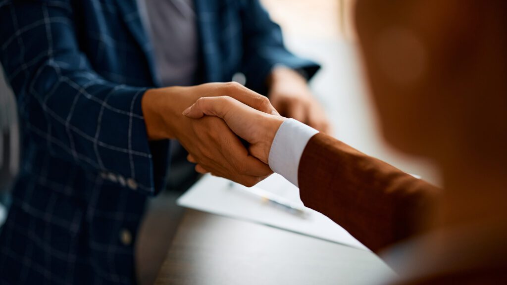 A business owner shaking hands with a digital marketing employee